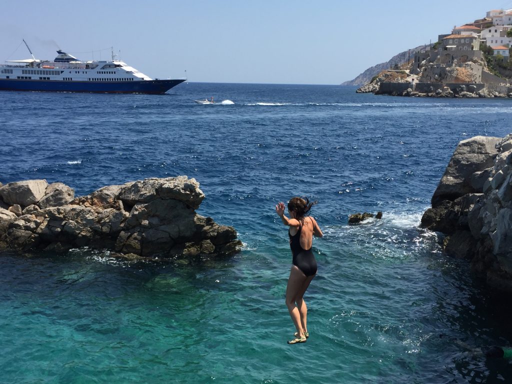 Diving in crystal waters in Hydra, Greece